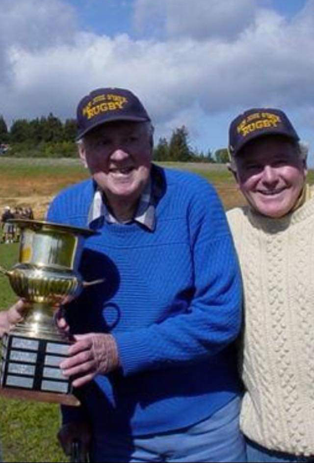 (L) Ron "Doc" Macbeath hoisting his namesake Trophy. On the right is former head coach Mike McDonald. 